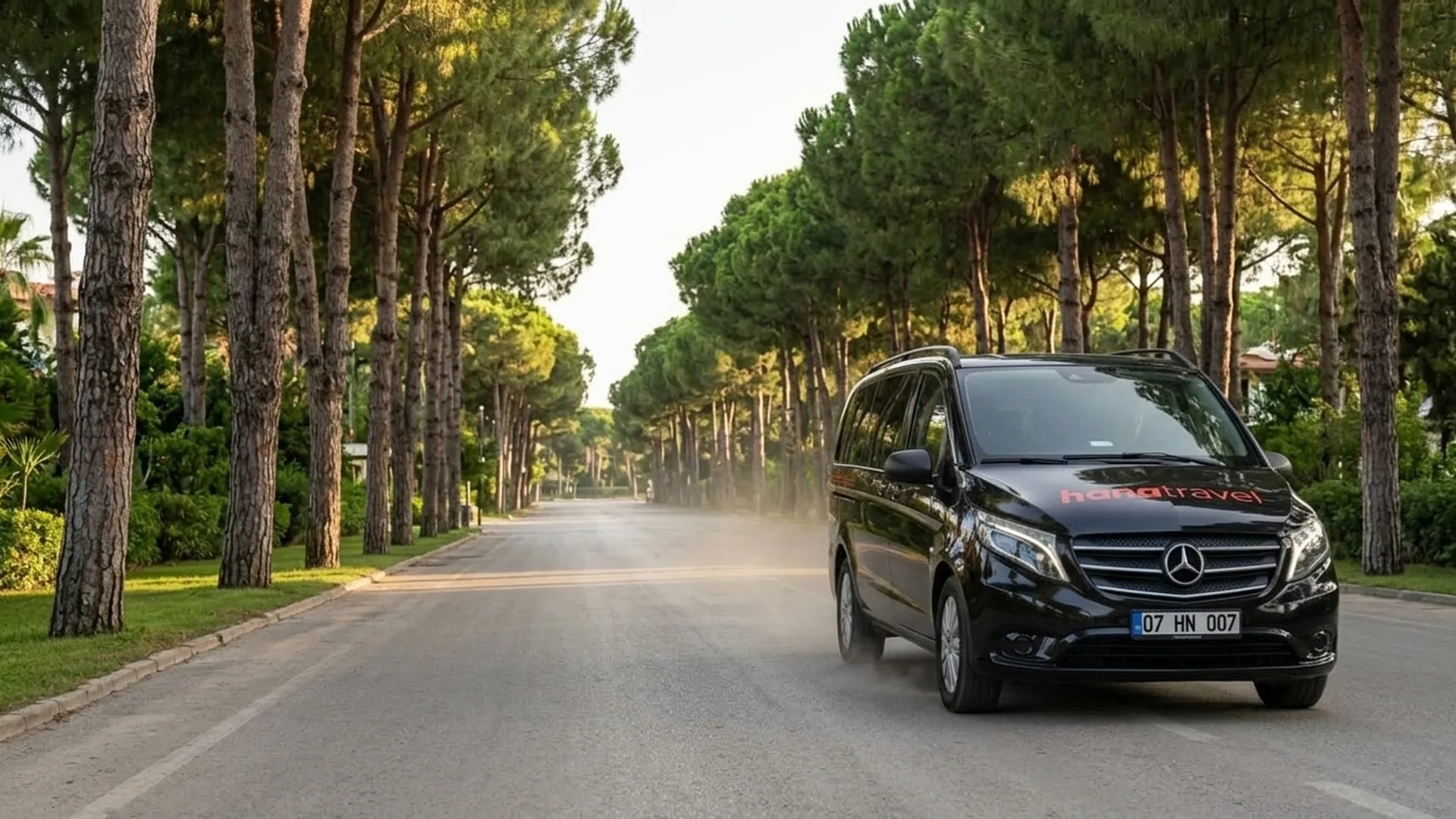 Black Hana Travel Mercedes Vito on a pine-lined resort road during an Antalya Belek transfer